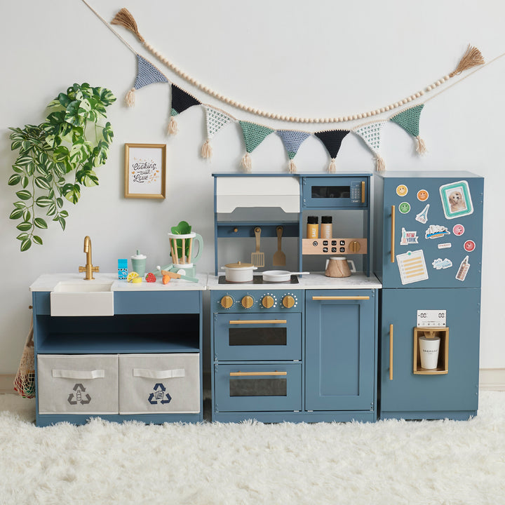 A TEAMSON KIDS - LITTLE CHEF ATLANTA LARGE MODULAR PLAY KITCHEN, STONE BLUE/GOLD with blue cabinets and a green plant.