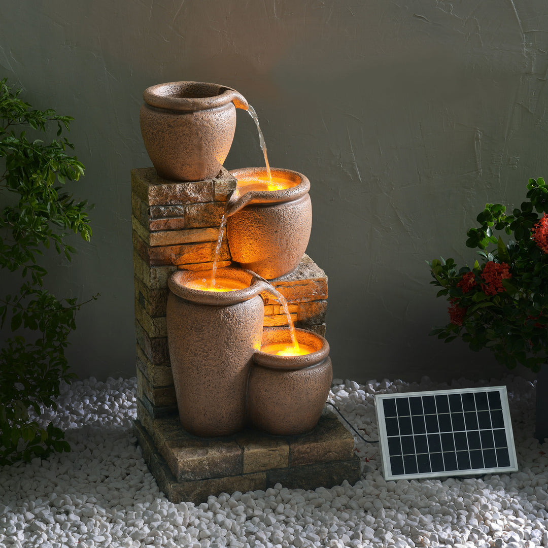 Teamson Home 30.71" 4-Tier Outdoor Solar Water Fountain with LED Lights, Terracotta with cascading urns at twilight.
