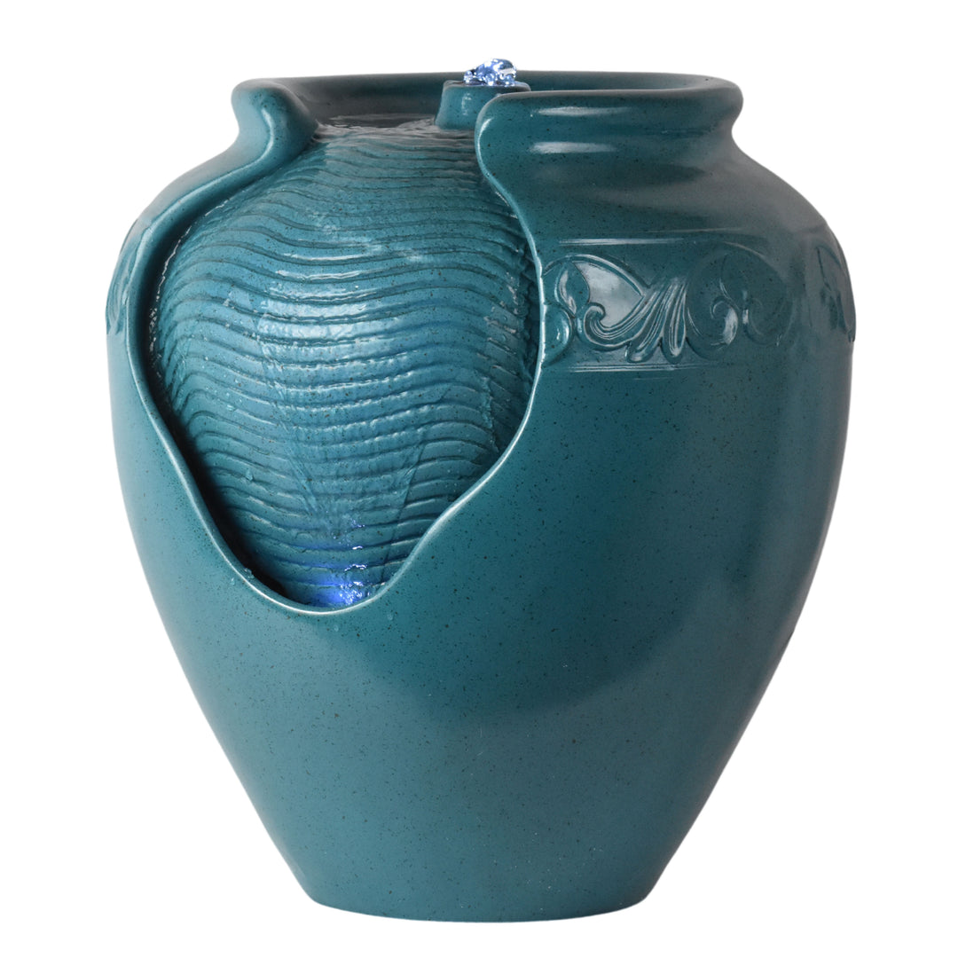 Close-up of the textured surface with water flowing over it on a teal vase-shaped water fountain