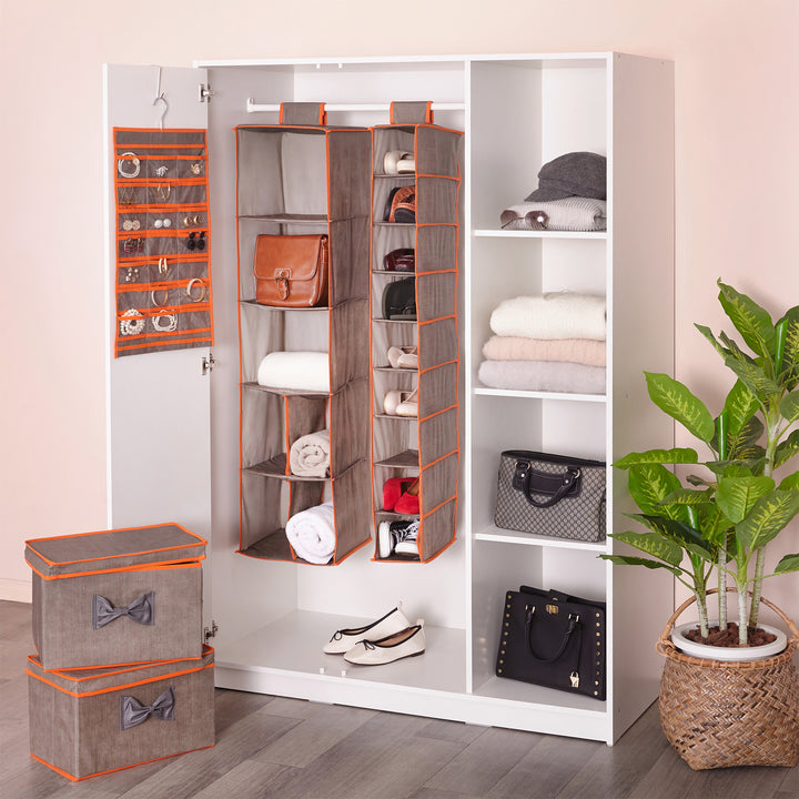 A Teamson Home 21-Pocket Hanging Jewelry Organizer, Gray with Orange Trim with jewelry in a variety of pockets next to a couple more organizers in a wardrobe