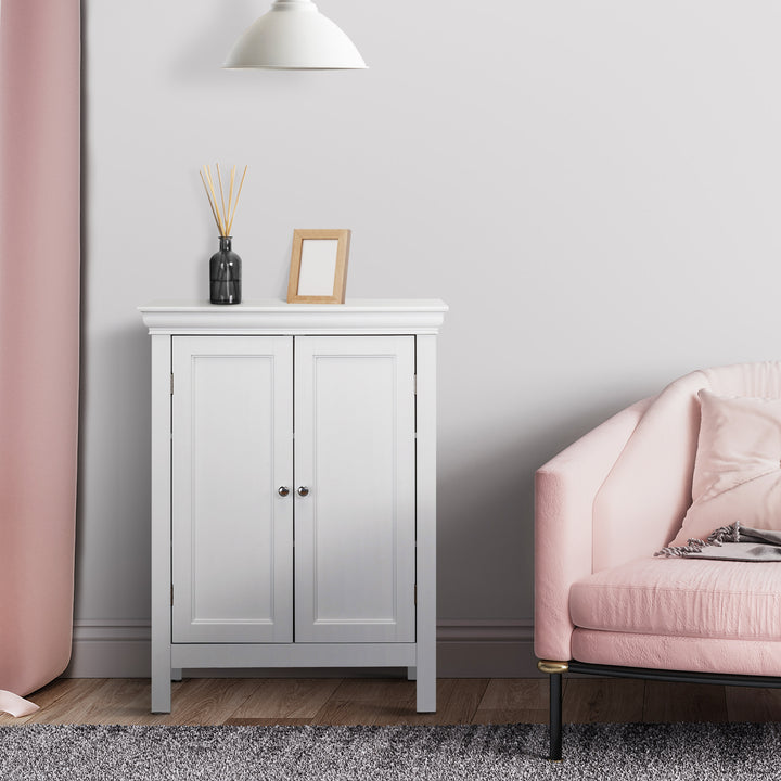 A White Teamson Home Stratford Floor Cabinet with chrome knobs underneath a white pendant light next to a pink accent chair