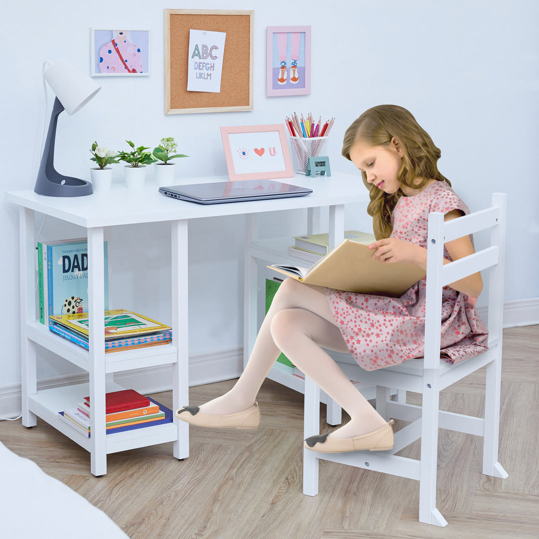 A young girl in a pink dress sitting on a white chair reading a book at a white desk with books on the shelves, and a laptop on the desk.