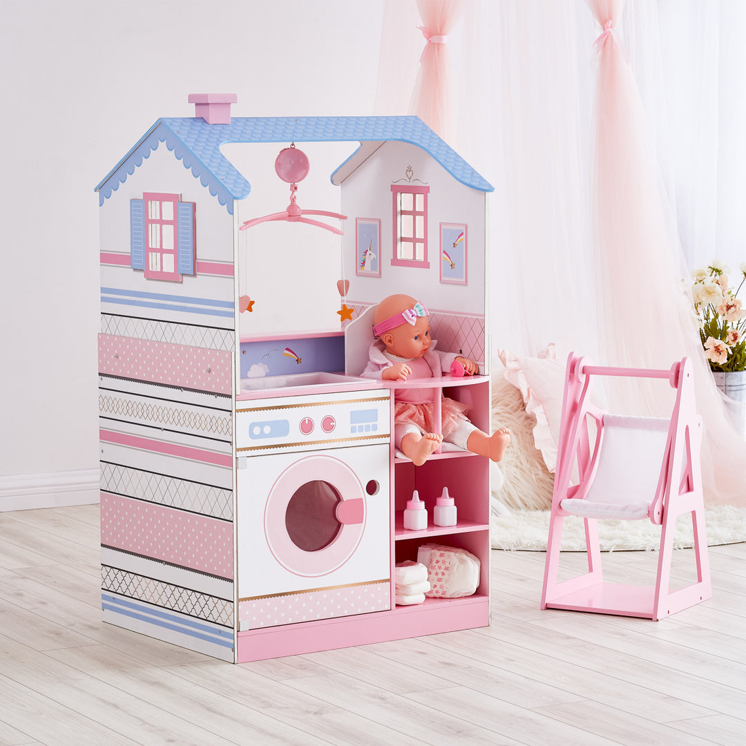 A view of the side with washing machine, sink, high chair, and storage shelves with a baby doll and accessories on the shelves, periwinkle and pinks.