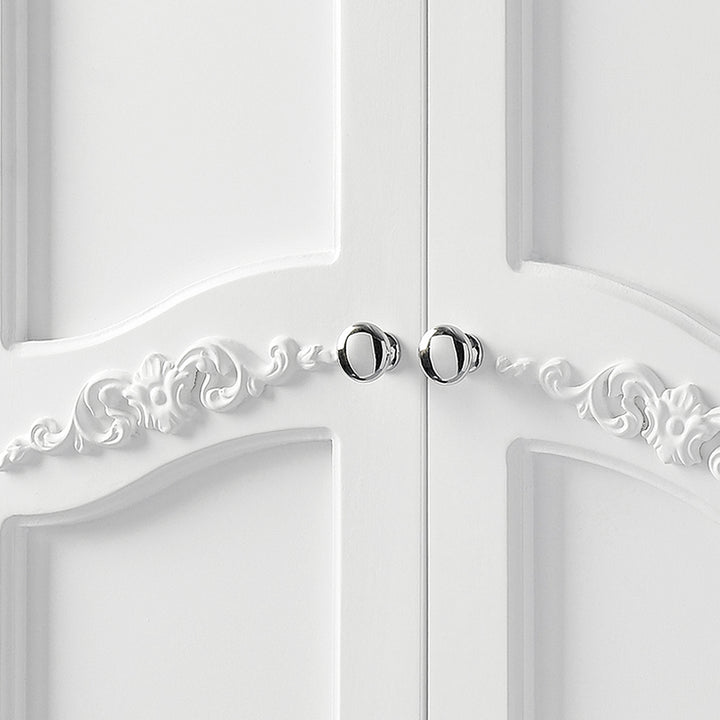 Close-up of chrome pull handles and decorative scrollwork on the cabinet handles