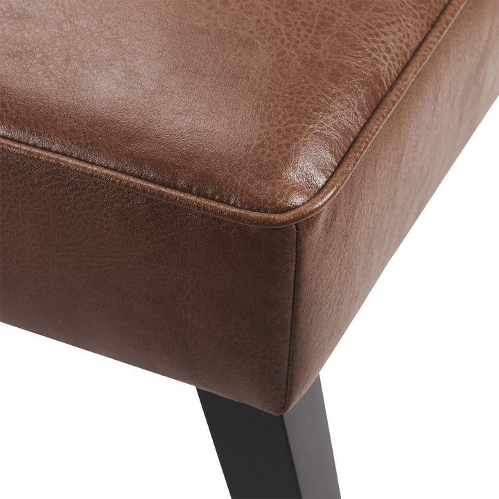 A close up of a brown Teamson Home Marc Faux Leather Lounge Chair with Pillow and Solid Wood Legs.