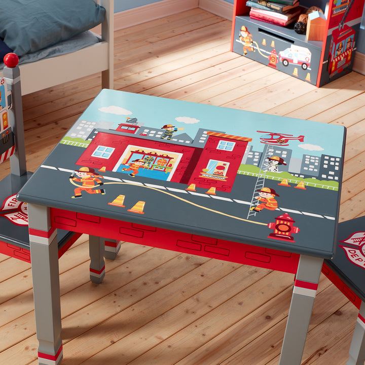 A child-sized table with gray legs and an illustration of a fire station in a city with a helicopter and firemen.