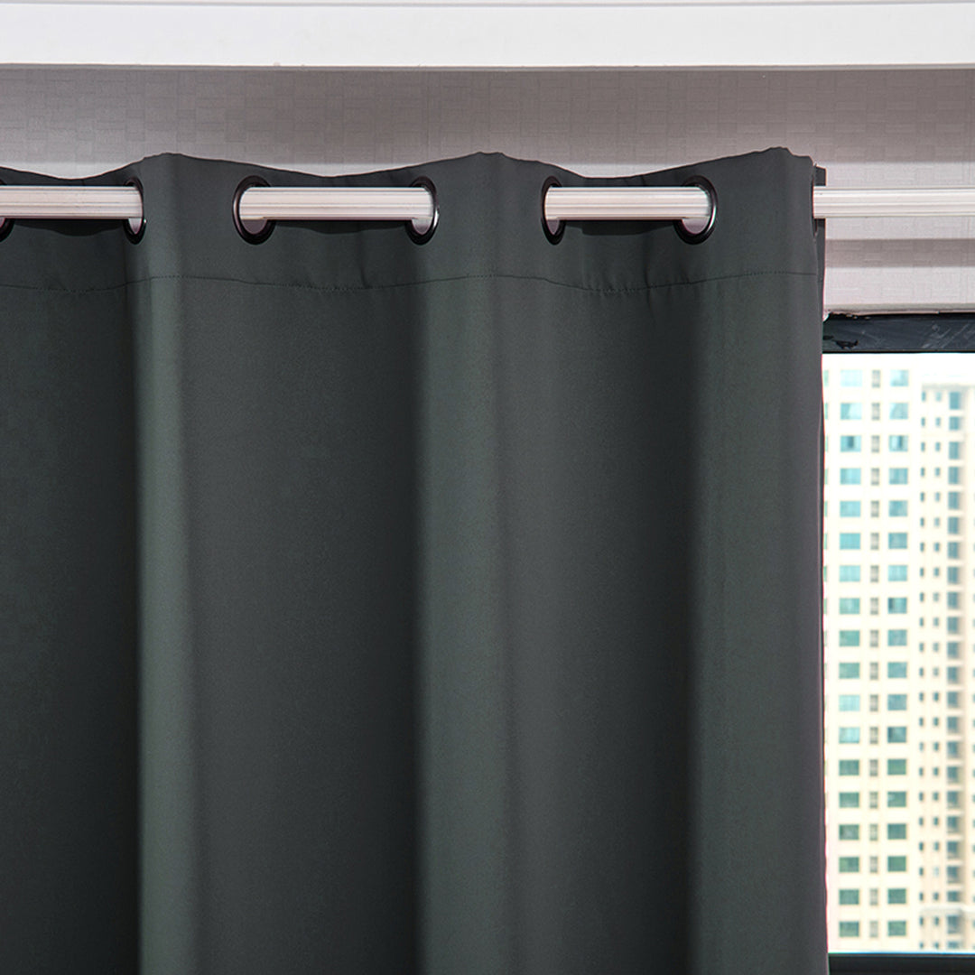 A close-up of Teamson Home 96" Delphi Premium Solid Insulated Thermal Blackout Window Curtain Panels with Grommets, Smoke Gray hanging against a window.