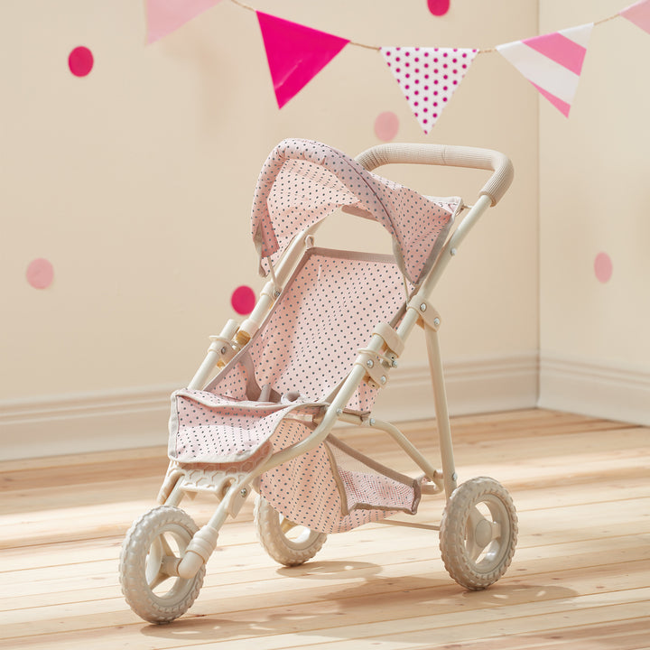 A pink and white Olivia's Little World Polka Dots Princess Baby Doll Jogging Stroller in a playroom with pink and white bunting and pink polka dots on the wall.
