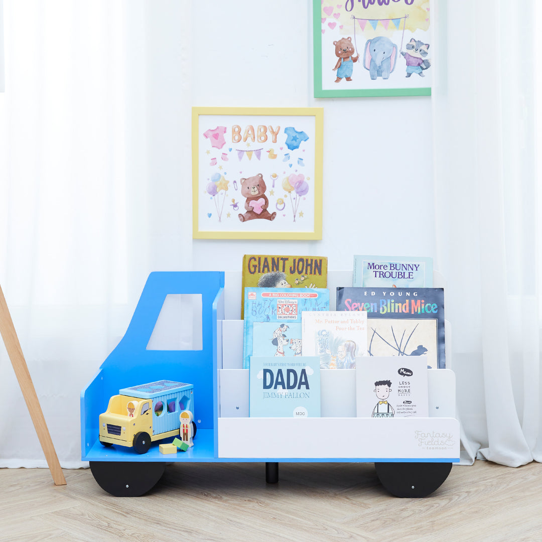 Fantasy Fields  Truck Wooden Display Bookcase, White/Blue, with books on the shelves and a toy truck in the storage space.