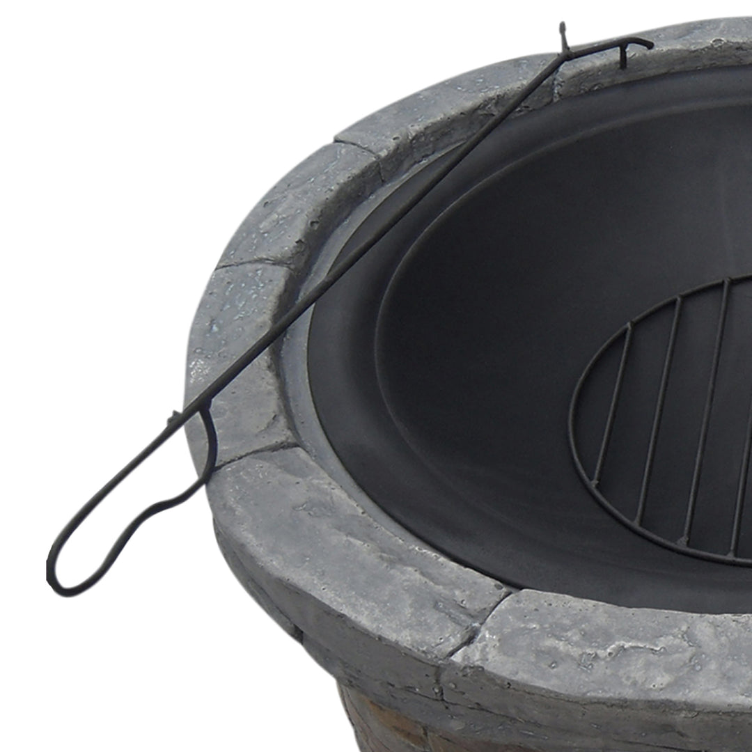 Top-down view of a Teamson Home 27" Outdoor Round Stone Wood Burning Fire Pit with Steel Base, Natural Stone with a metal grate and a poker tool.
