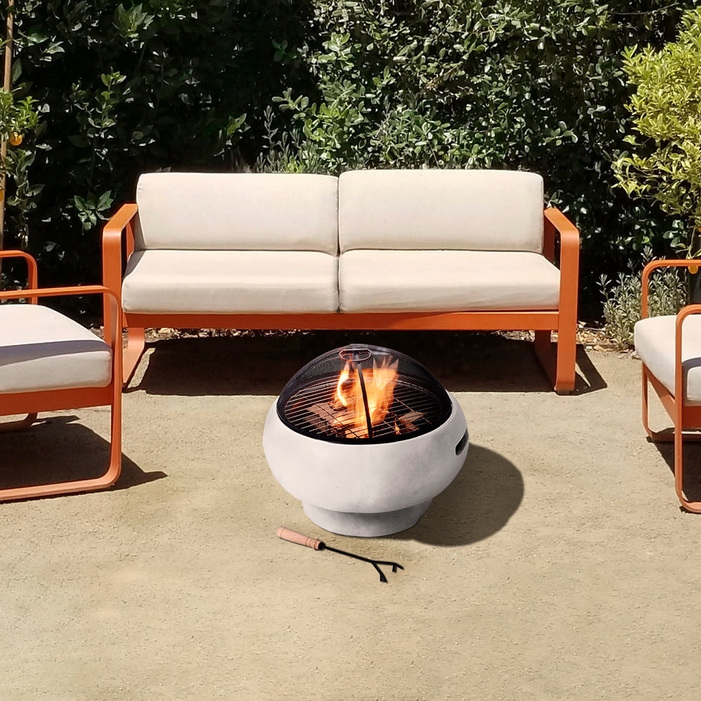 Modern outdoor seating arrangement with a central Teamson Home 21" Outdoor Round Stone Wood Burning Fire Pit with Faux Concrete Base, Gray.