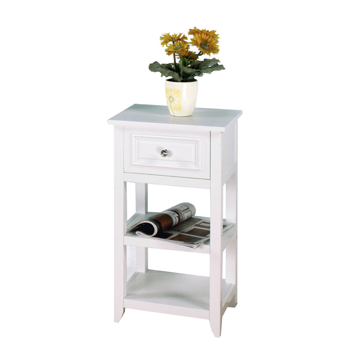 Teamson Home Dawson Accent Table with storage drawer and shelves, White with a planter on top and a magazine on one of the shelves below