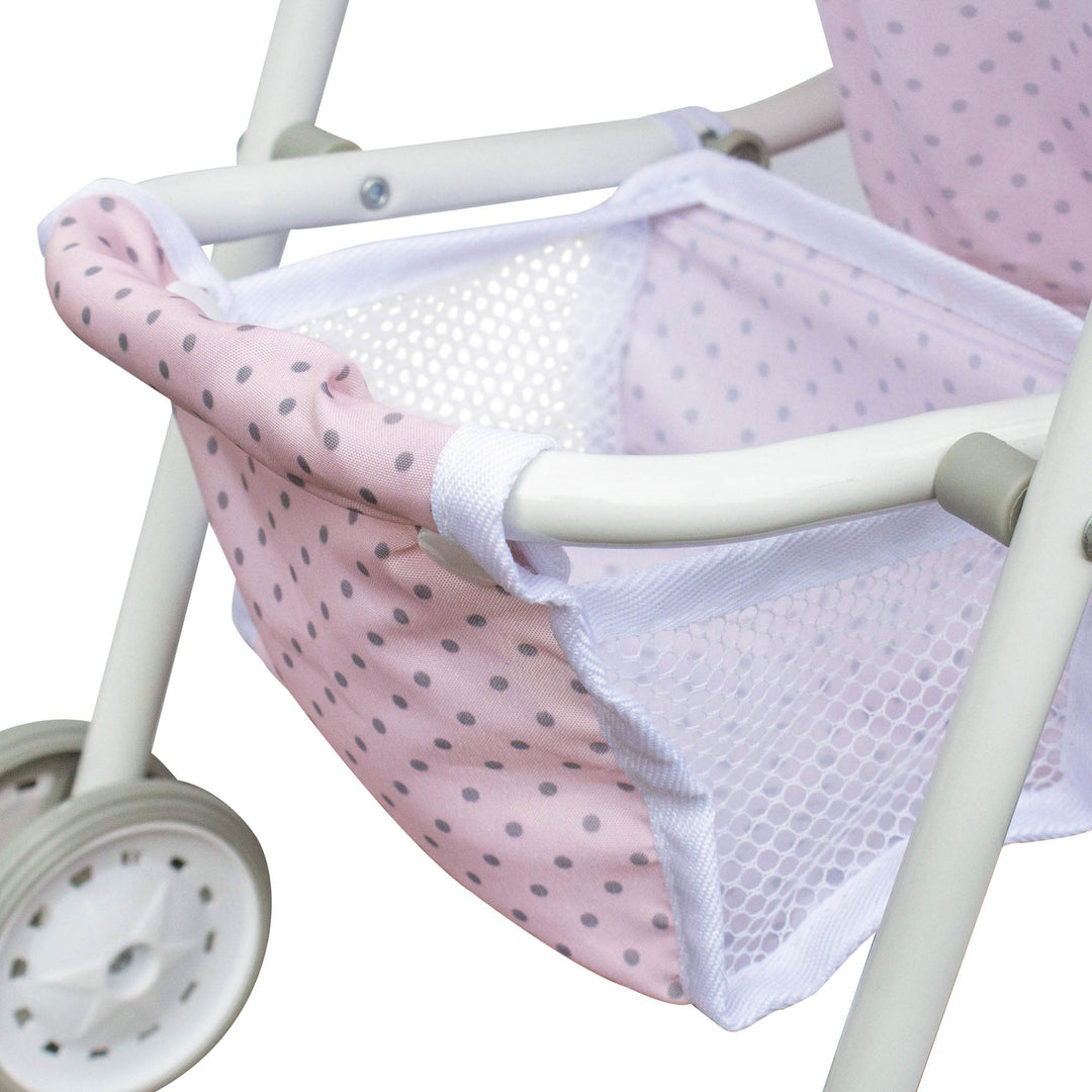 A close-up of a storage basket in pink and white located on the bottom of a baby doll stroller.