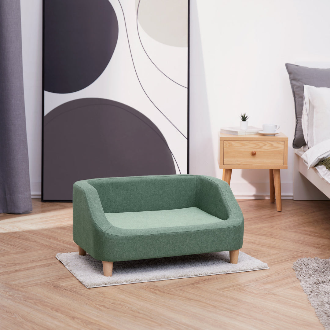 The Bennett Linen Sofa Pet Bed for Cats and Dogs in a two-toned sea green in a bedroom.