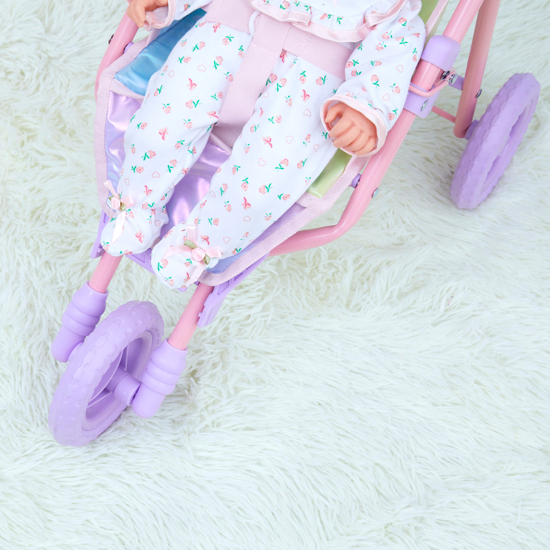 A view from above of a doll buckled into an iridescent baby doll jogging stroller.