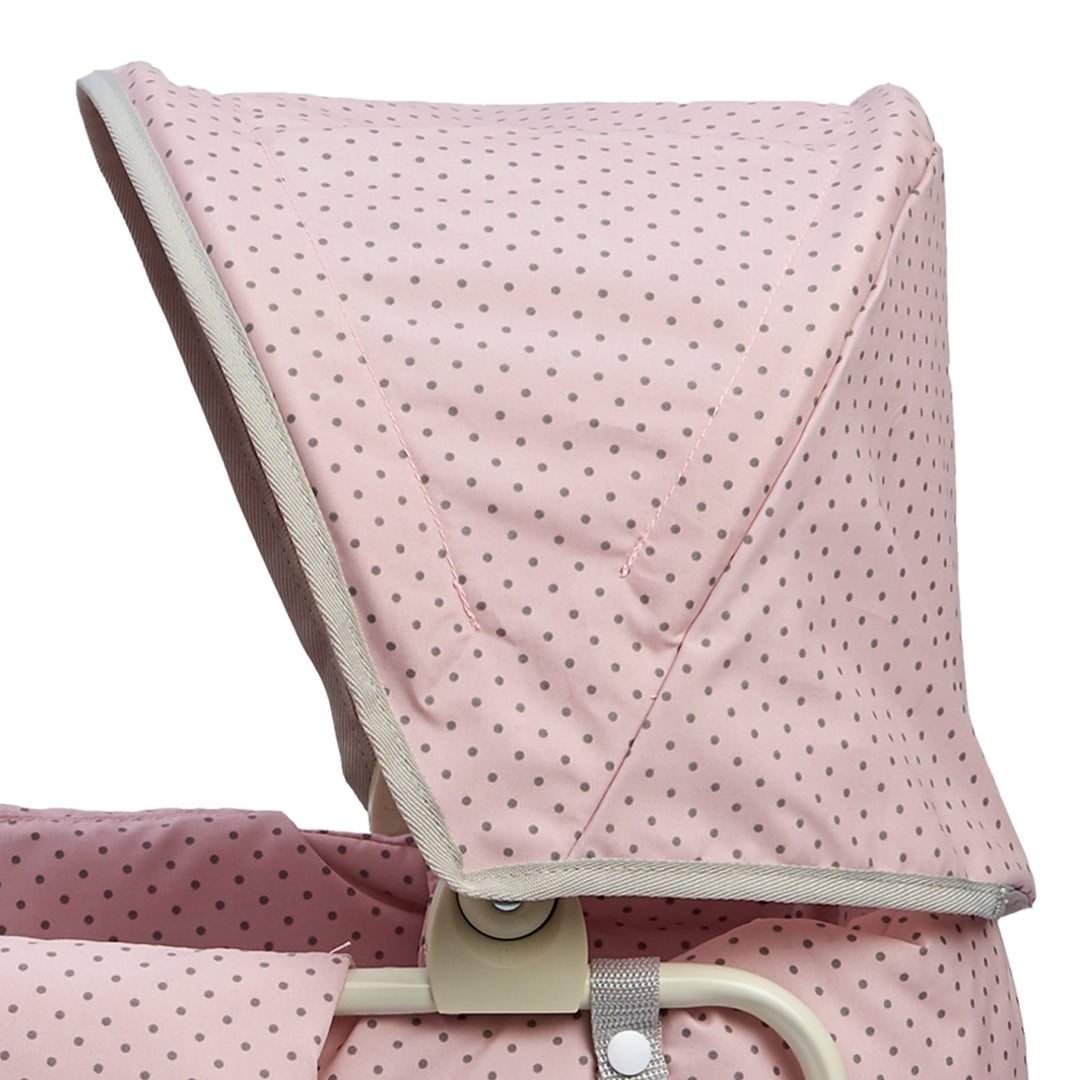 A close up of the retractable canopy in pink with gray polka dots.