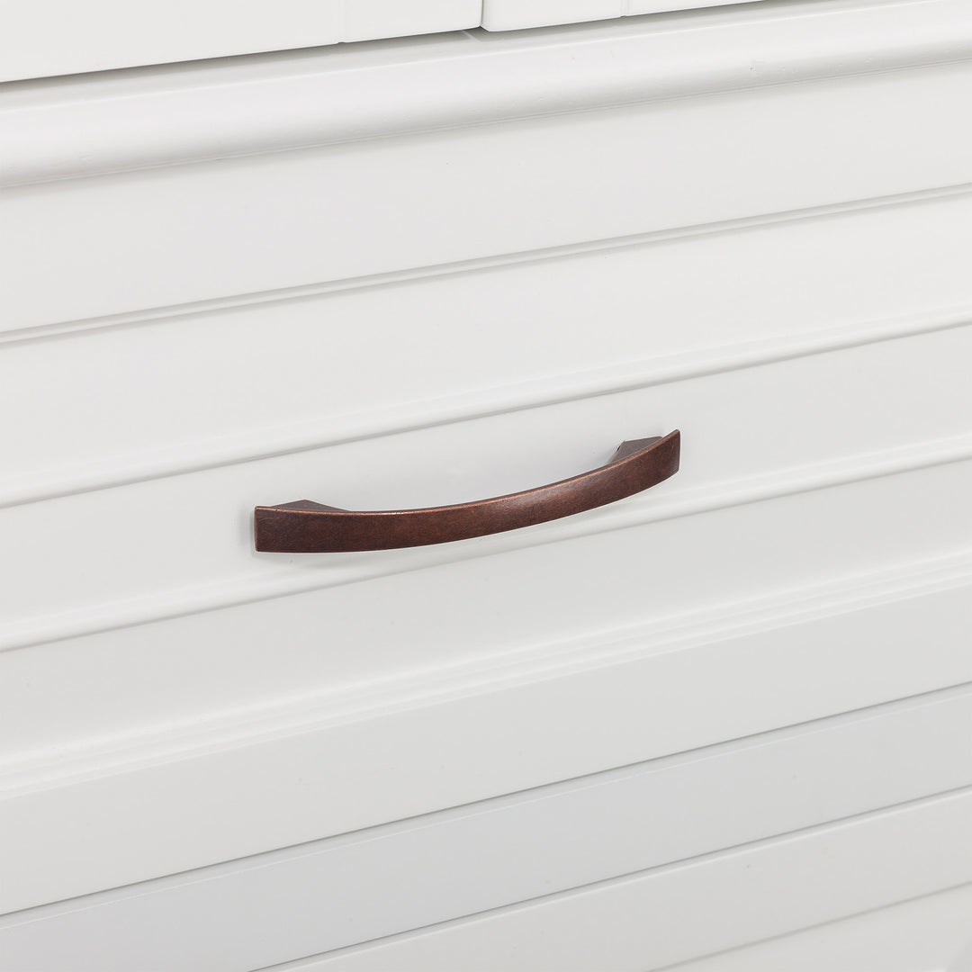 Close-up of a bronze' drawer handle on a Teamson Home St. James Wooden Linen Tower Cabinet with 2 Drawers, White.