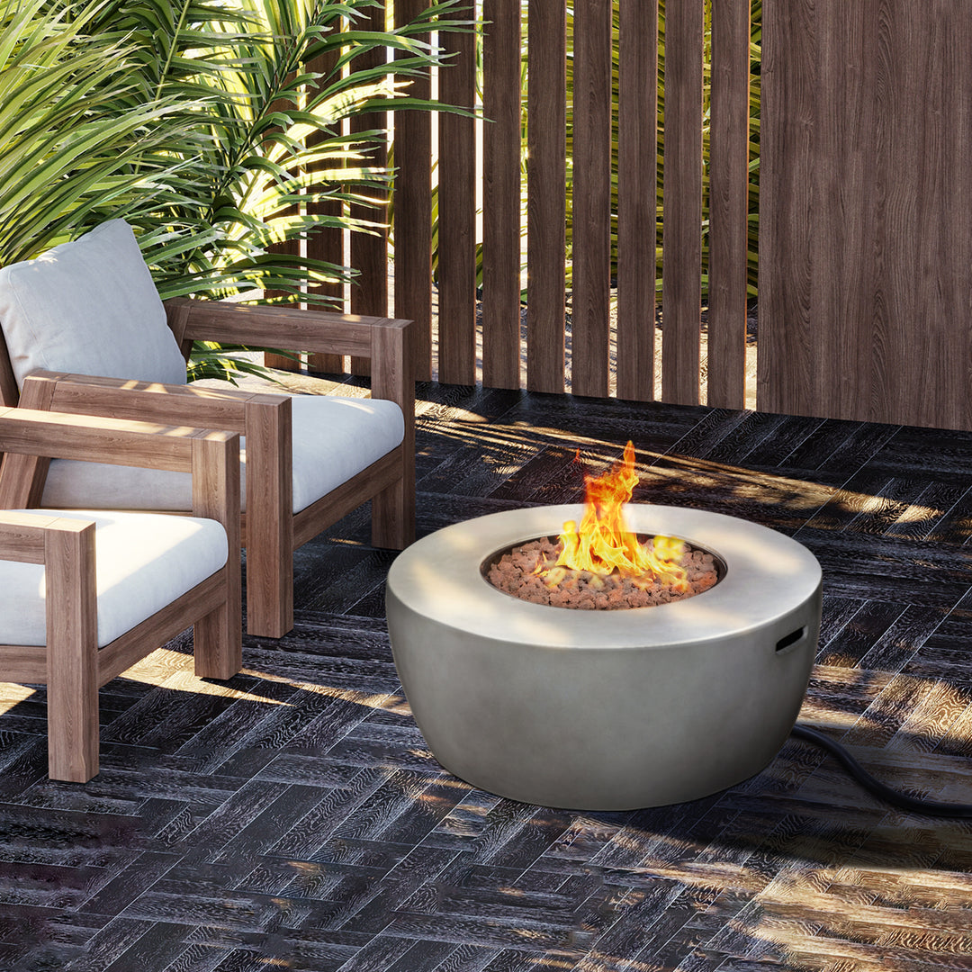 Modern outdoor seating area with a Teamson Home 36" Outdoor Round Propane Gas Fire Pit with Faux Concrete Base, Gray and wooden accents featuring sturdy construction.