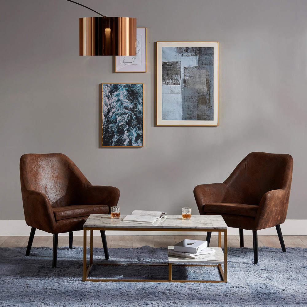 Two brown leather chairs and a Teamson Home Marmo Modern Marble-Look Coffee Table with Shelf, Marble/Brass in a living room.