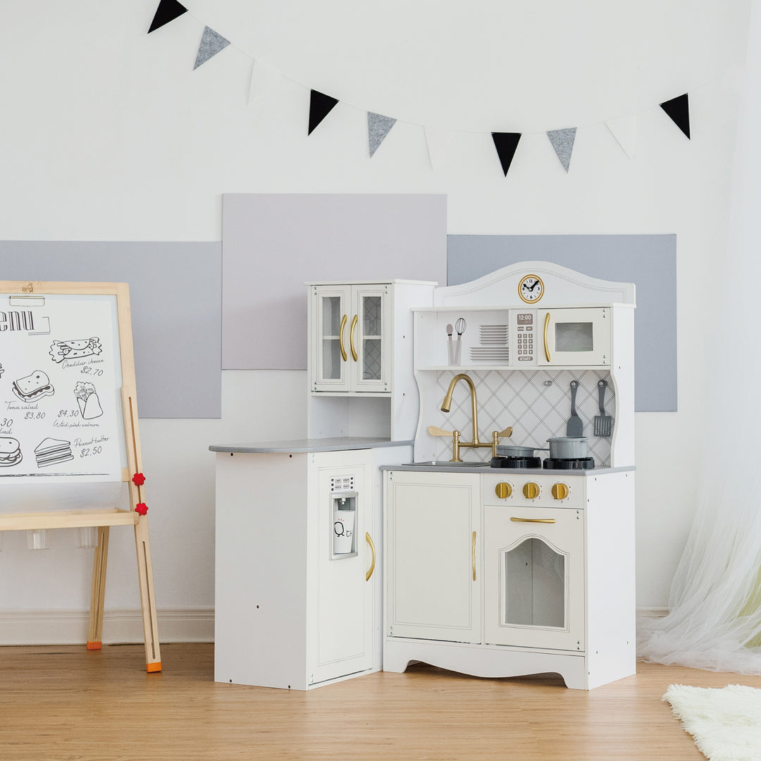 Child's Teamson Kids Little Chef Upper East Retro Play Kitchen with Effects in a clean, bright room with an interactive drawing easel in the background.