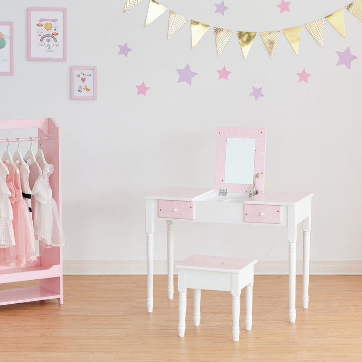 A girl's bedroom with a pink Fantasy Fields Kids Kate Twinkle Star Vanity Set with Foldable Mirror and Chair.