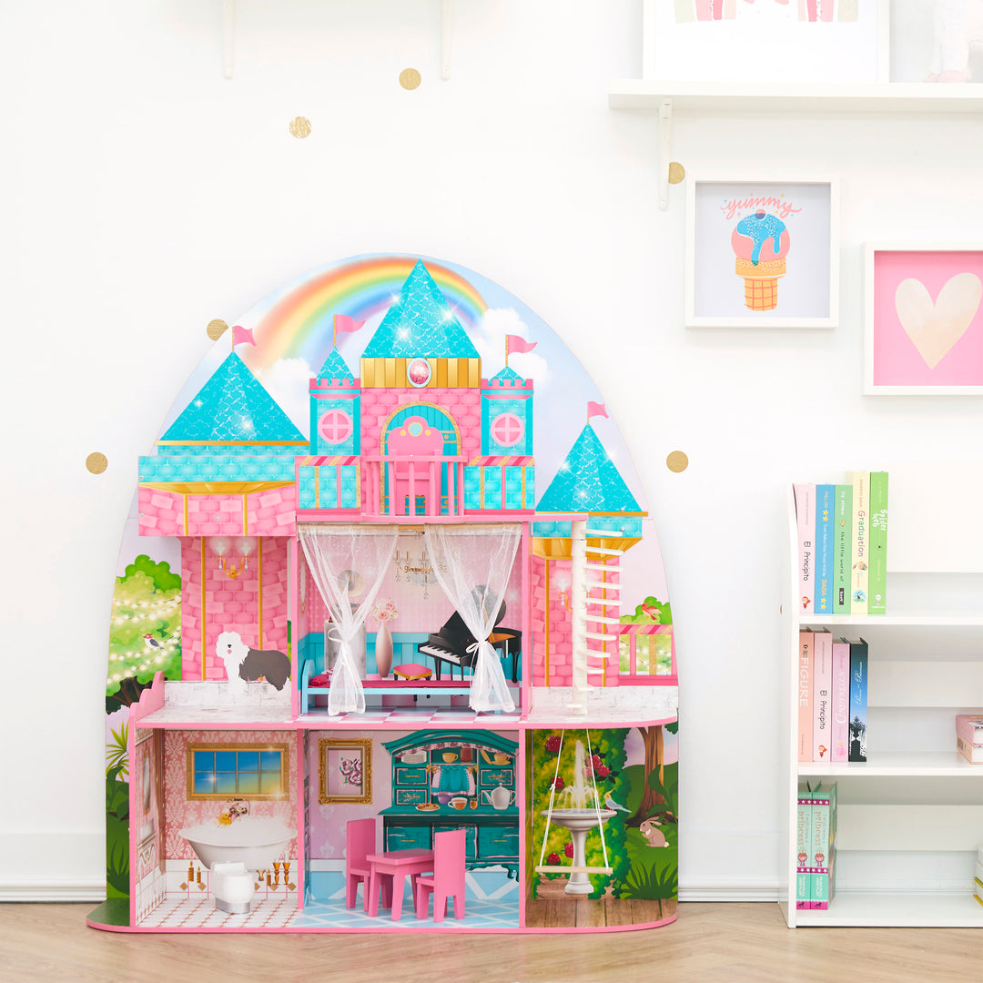A 3-story brightly illustrated castle doll house for 12" dolls in a playroom next to a white bookshelf.