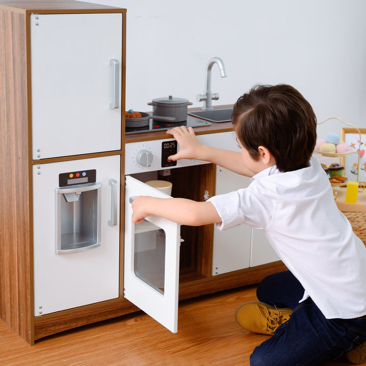 A child playing with a Teamson Kids Little Chef Palm Springs Classic Kids Play Kitchen with Accessories, Natural/White.