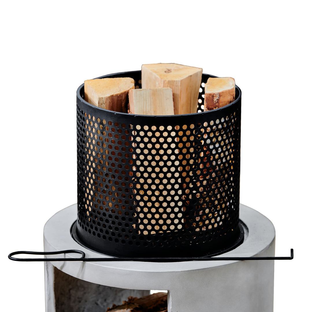 A close-up of the burn basket of the Teamson Home Outdoor 16" Wood Burning Fire Pit with Decorative Log Storage Base, Gray/Black