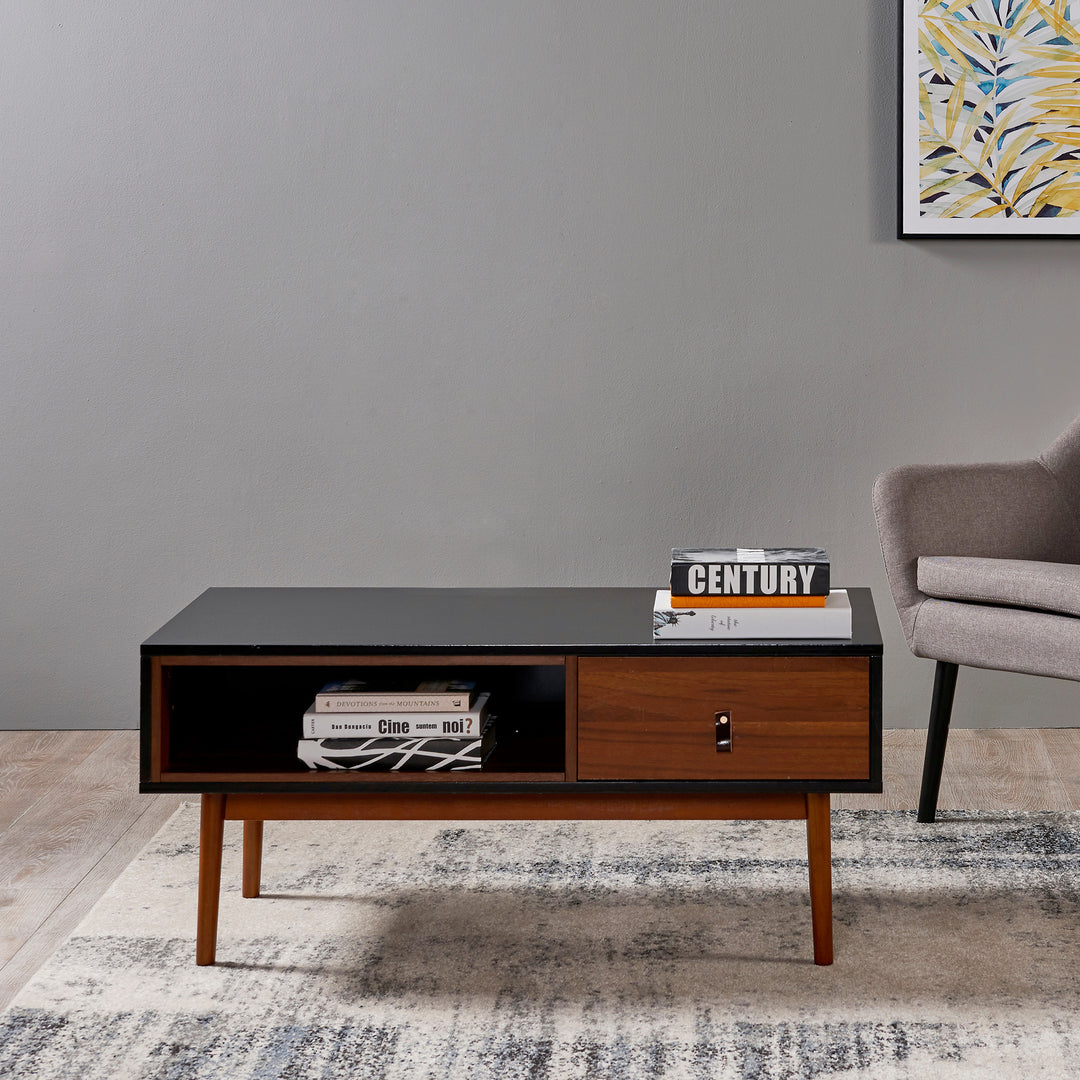 A Teamson Home Reno Coffee Table with Storage Drawer, Black/Walnut in a living room with a chairand a rug.
