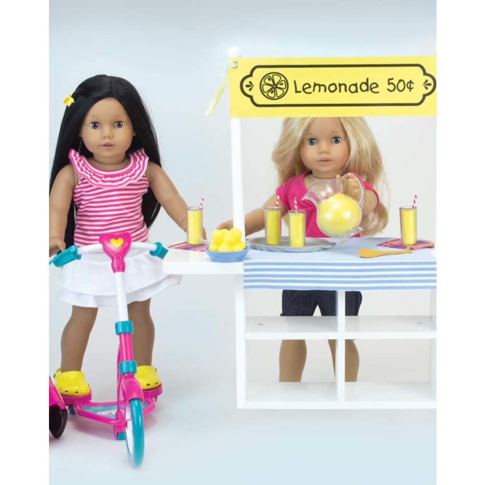 Dolls standing next to a table with Sophia’s Fresh Lemonade Drink Set with Pitcher for 18" Dolls.