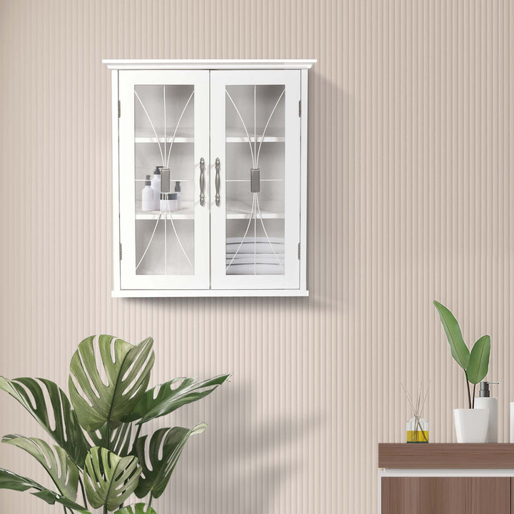 A Teamson Home White Delaney Removable Wall Cabinet, White mounted on a striped wall above a small table with a plant and toiletries.