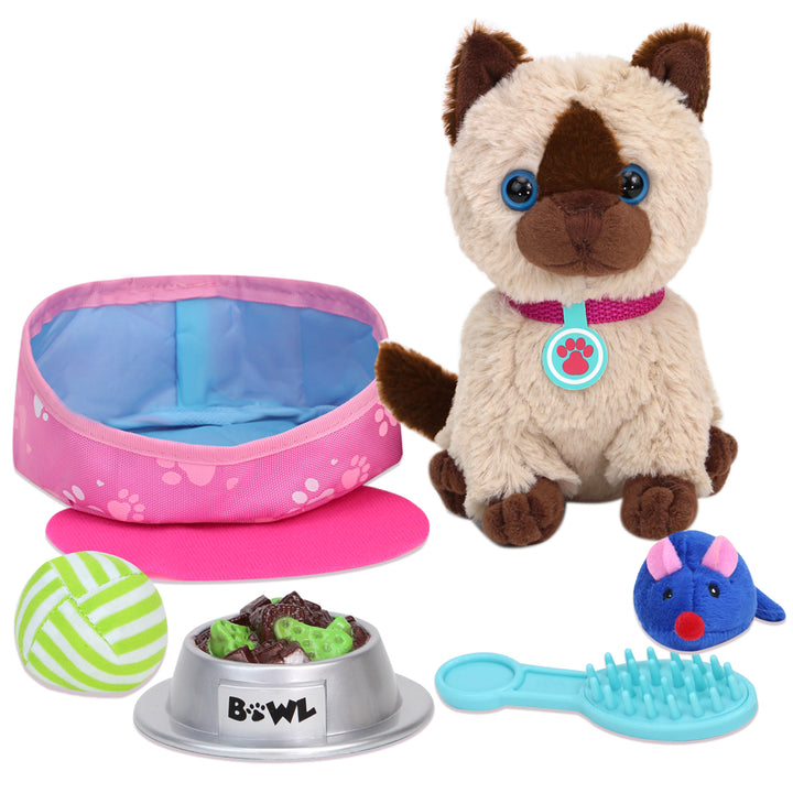 A play siamese kitten with a pink collar and blue tag, a blue toy mouse, a blue brush, a bowl of faux food, a green and white ball, a pink mat and a pink pet bed.