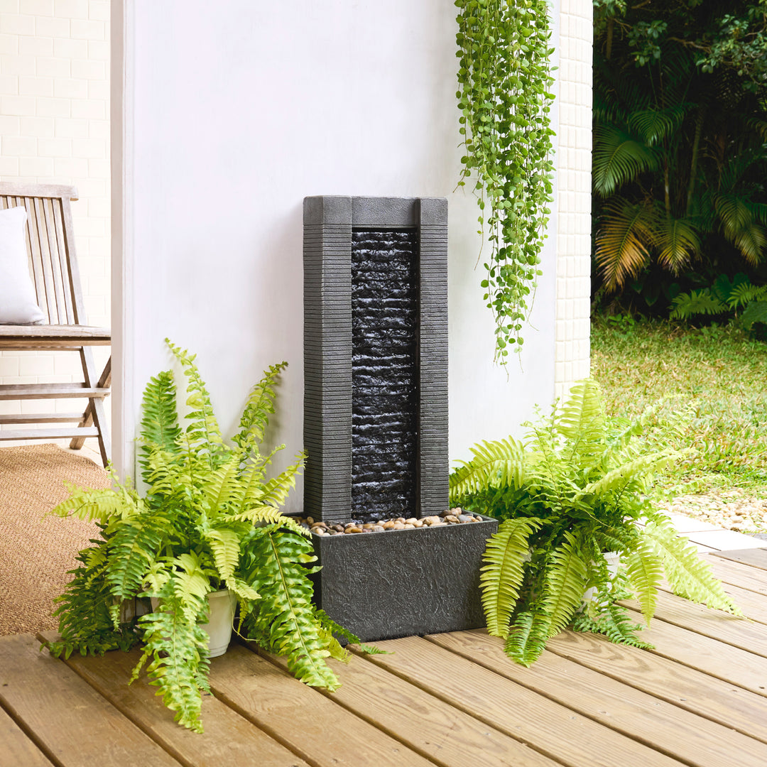 Outdoor patio with a Teamson Home Demeter Outdoor Water Fountain and potted ferns.
