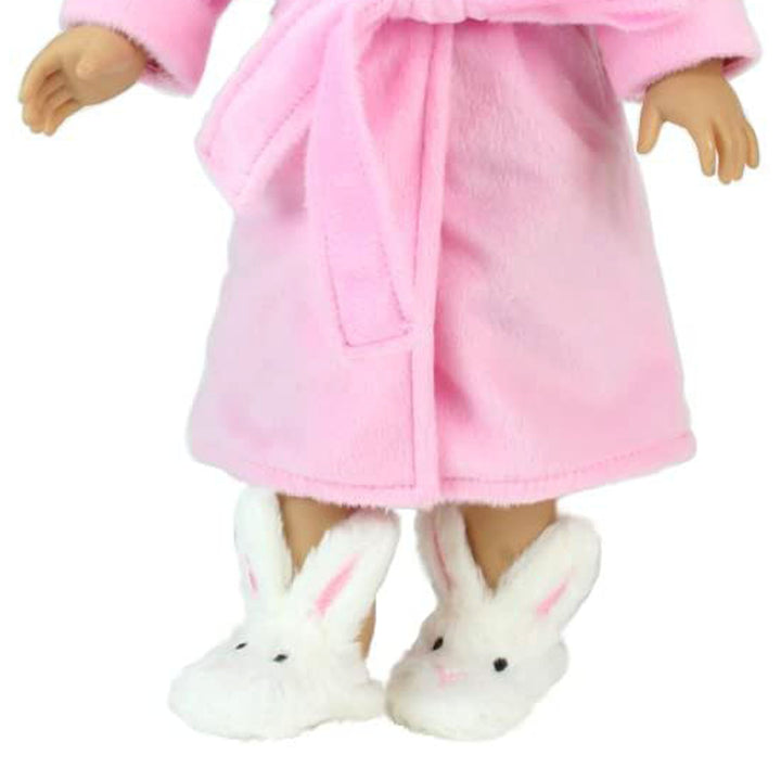 A doll wearing a pink robe and Sophia’s White Bunny Slippers with Rabbit Ears for 18" Dolls.