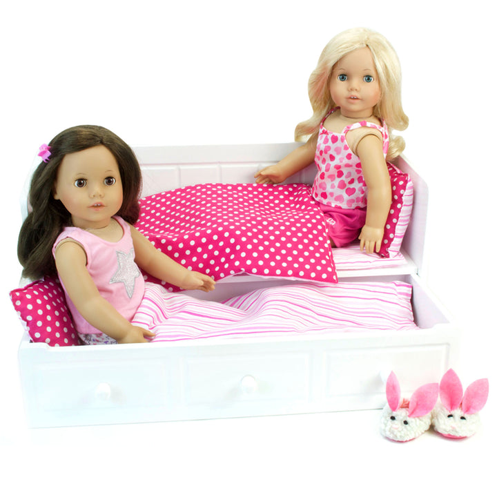 Two 18" dolls in a trundle bed with a pair of fuzzy white bunny slippers next to it.