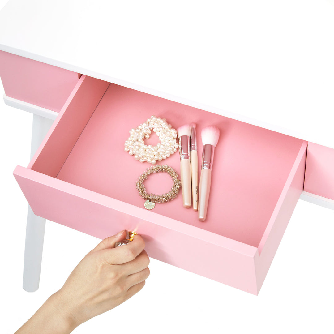 A view inside a pink and white vanity table's drawer.