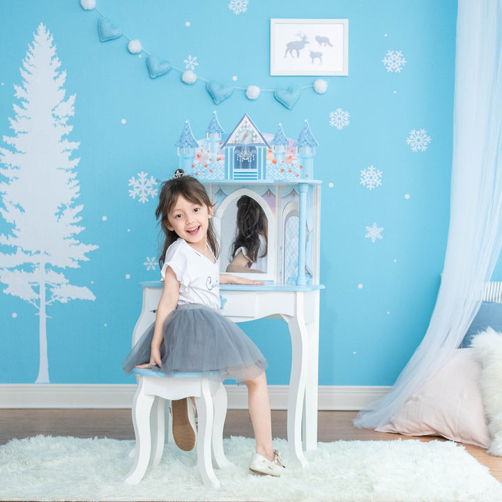 A girl sitting on a Fantasy Fields Kids Dreamland Castle Vanity Set with Chair and Accessories, White/Blue chair in front of a mirror.