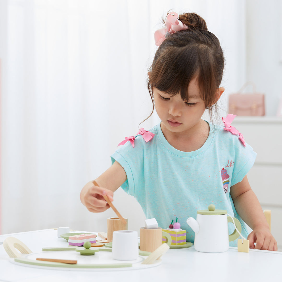 A young child plays with the Little Chef Frankfurt Wooden Tea sets play kitchen accessories 