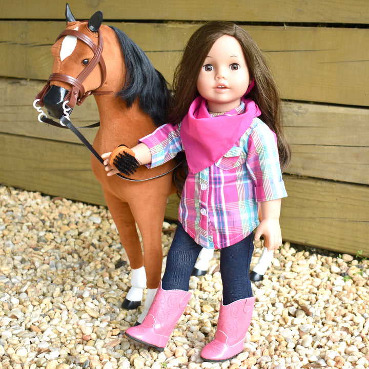 A Sophia's doll in a western outfit standing next to a horse.