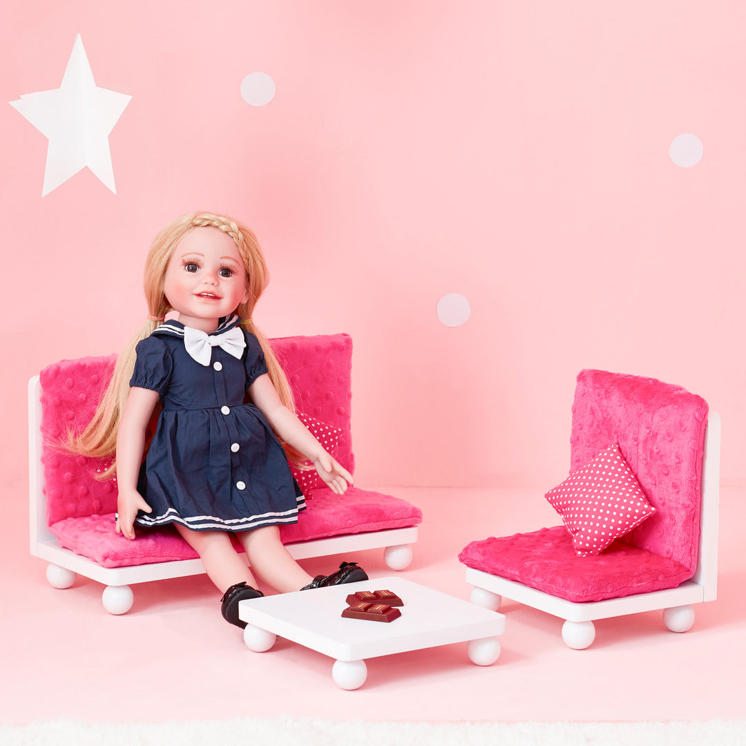 A doll sitting on Olivia's Little World Little Princess Lounge Set with Couch, Chair and Coffee Table, Hot Pink/White.