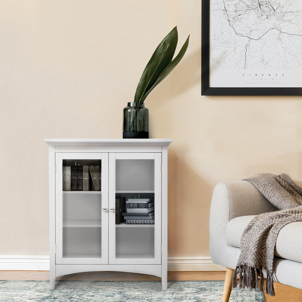 Teamson Home Madison Double Door Floor Storage Cabinet, White in a living room next to a sofa with books inside