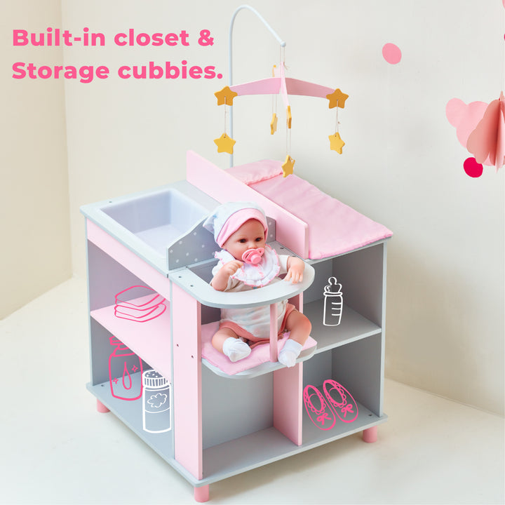 A baby doll changing station in pink and gray with white polka dots with a baby doll sitting in the high chair and the caption "Built-in closet & storage cubbies."