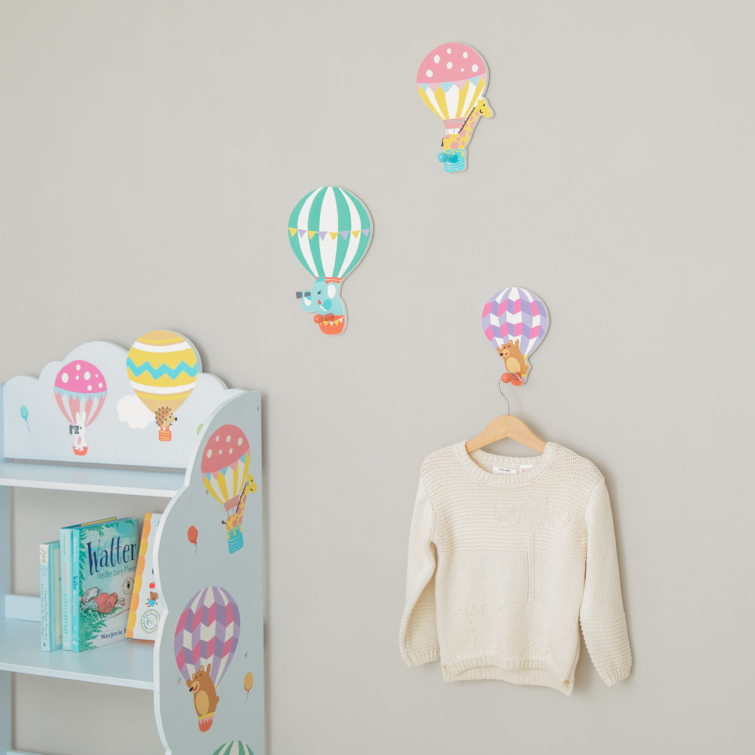 A child's room with hot air balloons on the wall and a Fantasy Fields Kids Peg Coat Hanger Hooks for organization.