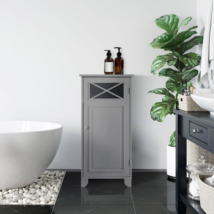 A Teamson Home Dawson Gray Floor Storage Cabinet with Door between a tub and potted plant in a white bathroom