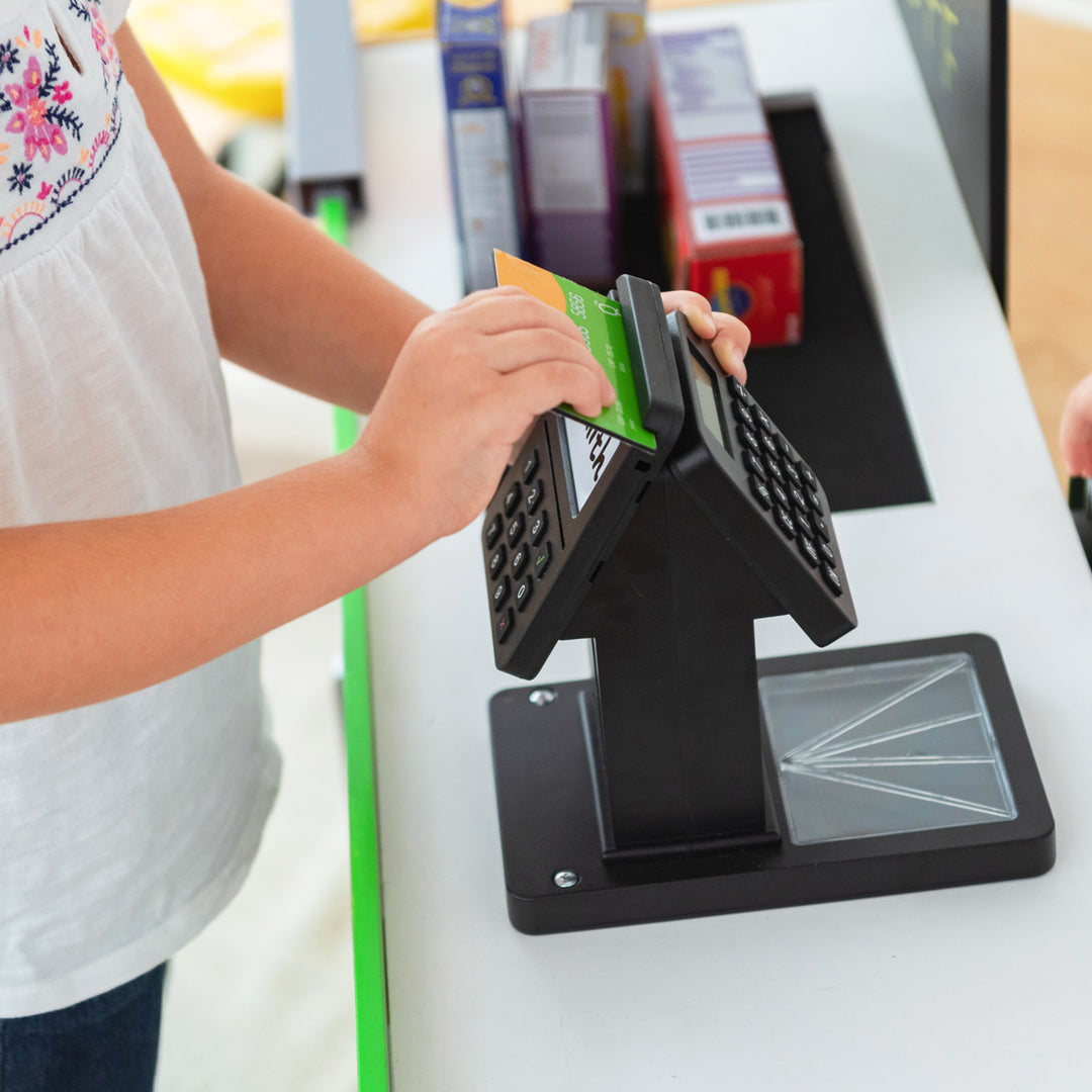 Child swiping a card through the payment processor. 