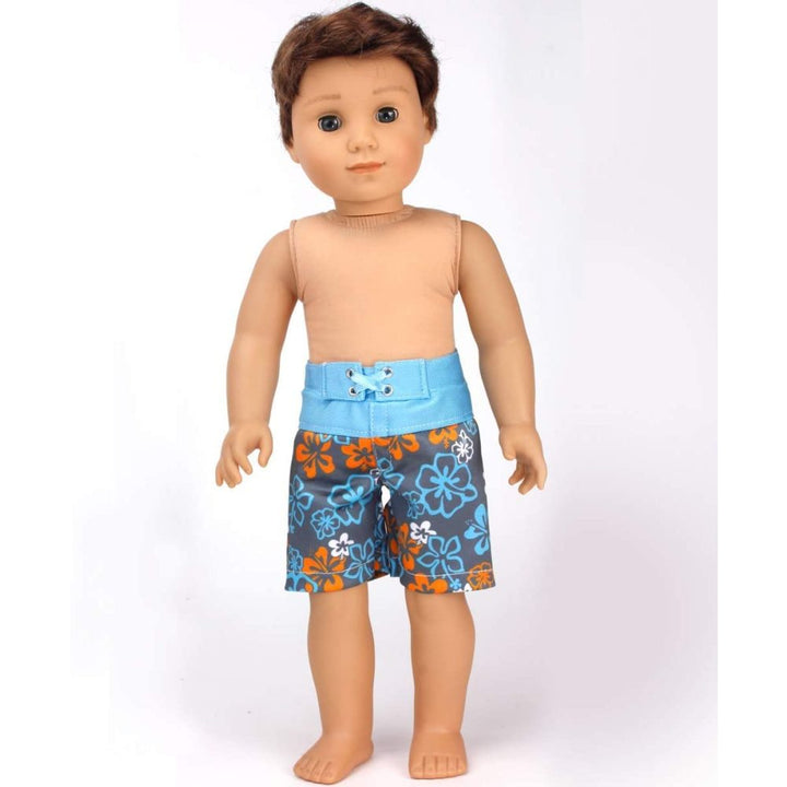 A brunette 18" boy doll with brown eyes wearing a pair of blue and gray floral swim shorts.