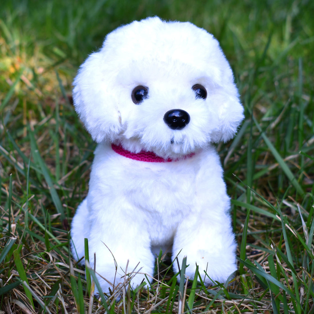 A realistic white stuffed dog in grass, perfect for pretend play or aspiring veterinarians.