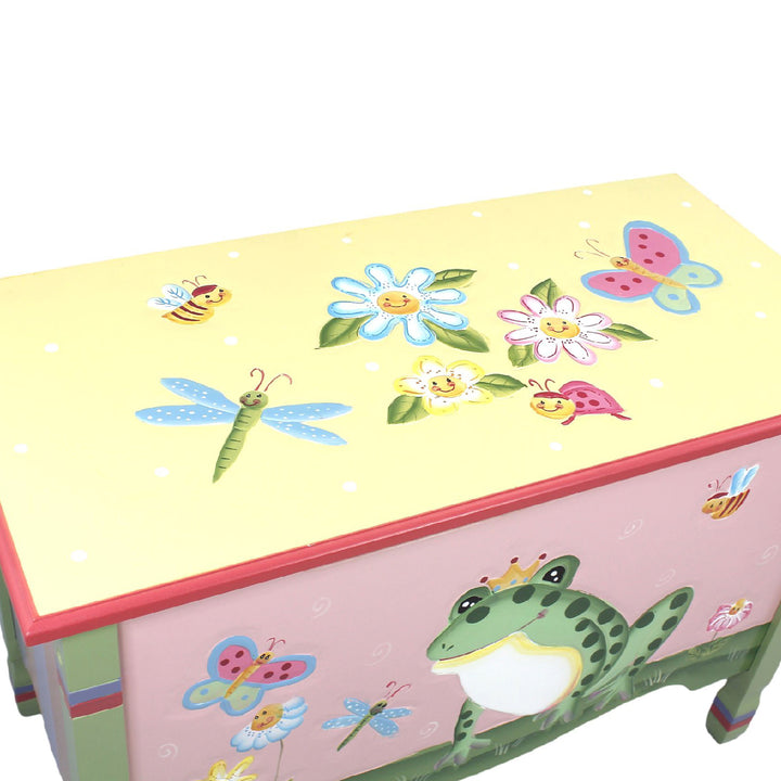 A Fantasy Fields Kids Magic Garden Kids Wooden Toy Storage Chest, Multicolor with frogs and butterflies on it.
