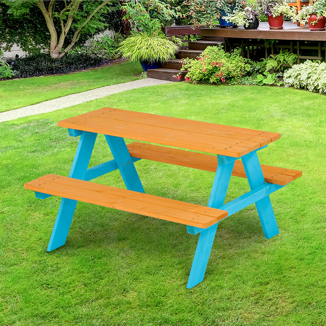 Teamson Kids Child Sized Wooden Outdoor Picnic Table, Warm Honey/Aqua in a grassy green backyard.