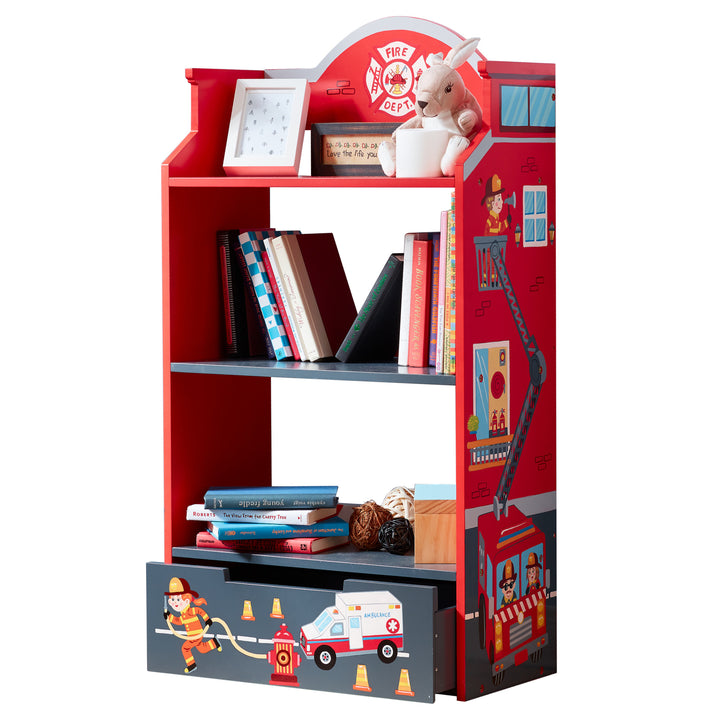 A Fantasy Fields Little Fire Fighters Bookshelf with Drawer, Red with a teddy bear and books.